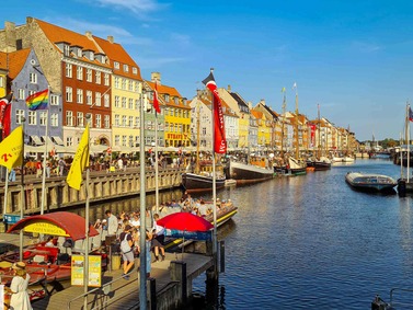Denmark: Colorful buildings line Nyhavn canal with boats and bustling waterfront activity.