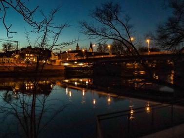 Ingolstadt, Germany: Night view of Danube River with city lights reflected in water.