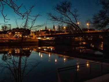 Ingolstadt Travel Guide: Night view of the Danube River with city lights reflected in the water.