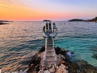 Ksamil Travel Guide: Iconic sea sculpture at sunset overlooking the Ionian islands in the Albanian Riviera.