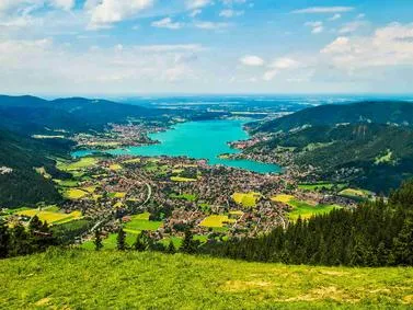 Scenic view of a tranquil lake surrounded by lush greenery, reflecting the clear blue sky.