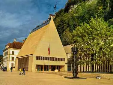 Liechtenstein: Modern parliament building with distinctive architecture against a hillside.