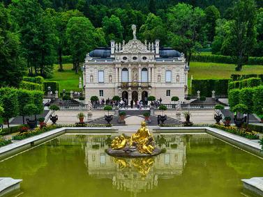 Linderhof Palace, Bavaria, Germany. Baroque architecture with golden statues and reflecting pool.