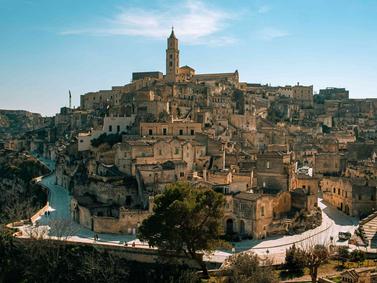 Matera, Italy. Ancient cave dwellings and stone structures under clear skies.