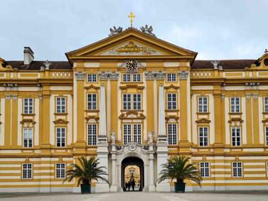 Melk, Austria. Melk Abbey's yellow facade with white detailing stands under overcast skies.