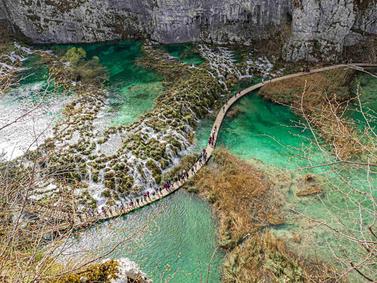 Plitvice Lakes, Croatia. Wooden walkway meandering through turquoise waters and waterfalls.