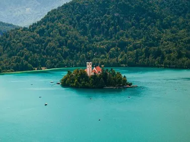 Slovenia: Island with church in Lake Bled, surrounded by forested hills.