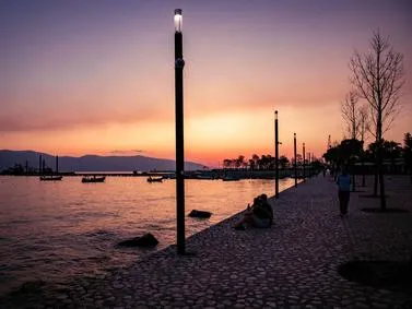 Vlora Travel Guide: Sunset over the Adriatic Sea promenade with traditional boats in coastal Albania.
