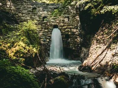 Wolfsklamm Travel Guide: Scenic Tyrol gorge featuring waterfalls, suspension bridges, and lush vegetation.